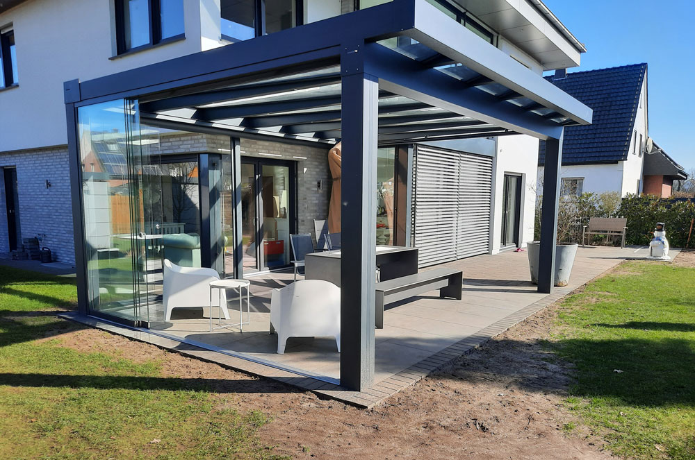 Geradliniges Aluminium-Terrassendach mit Glaswänden an einem Wohnhaus